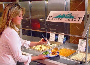 A person is serving themselves food from the dining commons. 